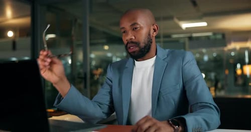 Night, laptop and black man in office with eye strain, burnout or overtime fatigue in finance