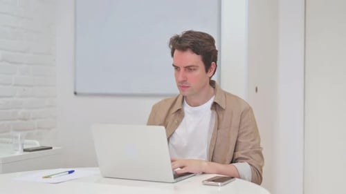 Busy Young Man Typing on Laptop