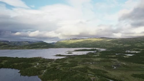 Pull-Back Shot Of Tranquil Green Landscape With Houses And Serene Waters