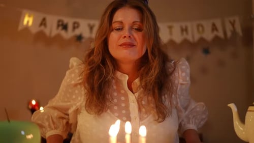 Woman Celebrates Birthday with Cake and Candles