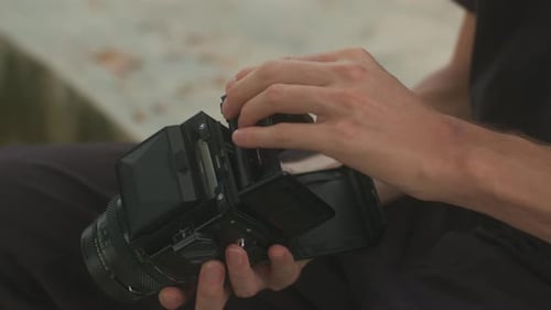 Photographer Reloading Medium Format Film Camera