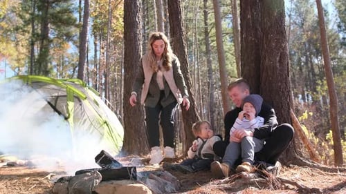 Family Camping with Campfire in a Pine Forest