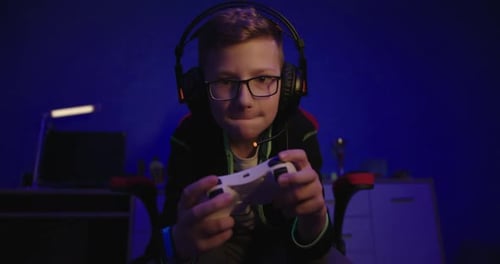 Teenage Boy Plays Video Game at Night
