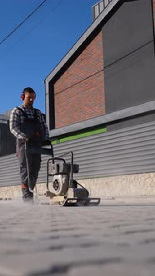 Adult Using Power Tool on Paving Stones