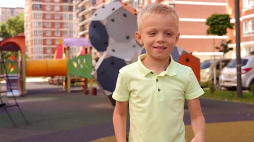 A Little Boy is Having Fun on the Playground He Gives a Thumbs Up