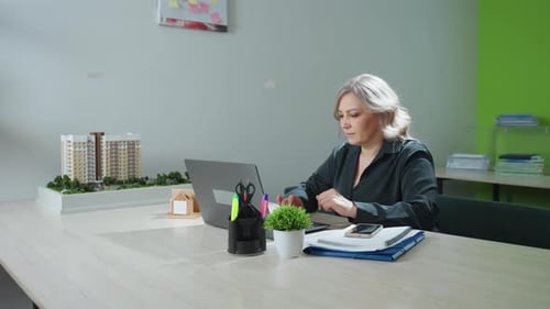 Real Estate Accountant Works on Laptop and Pauses for Coffee