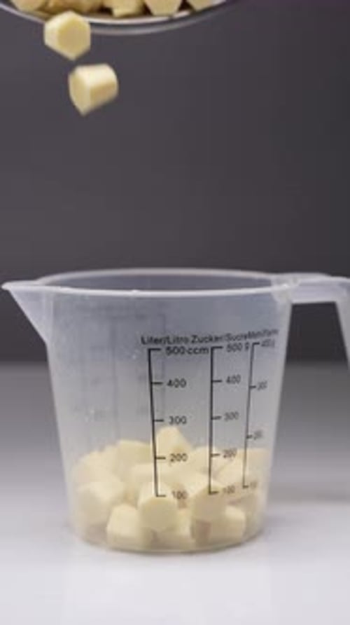Diced Ingredients Falling Into Measuring Cup