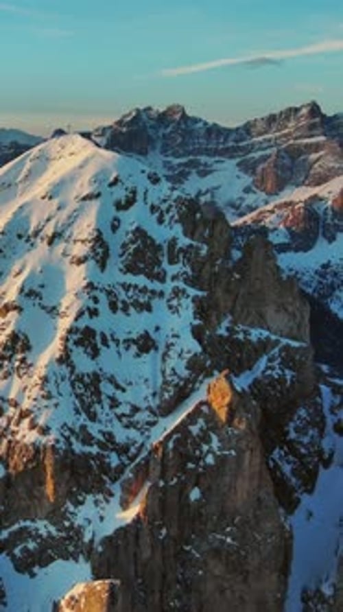 Rocky snow mountains at sunrise aerial