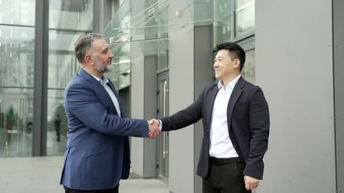 Business Men Shaking Hands Outside Office Building
