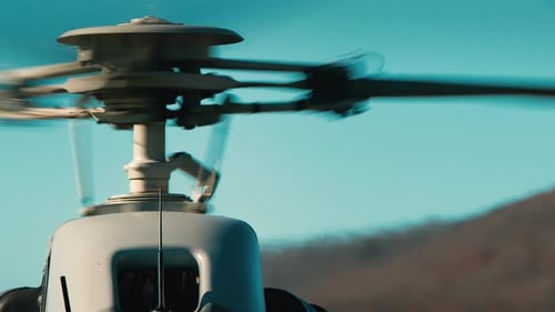 Close up on a helicopters rotors as they spin in slow motion.