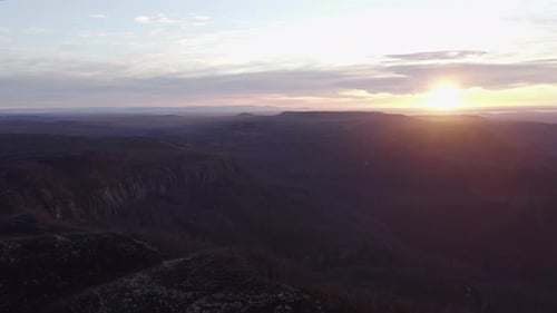Aerial shot of rolling hills during sunrise on a beautiful day.