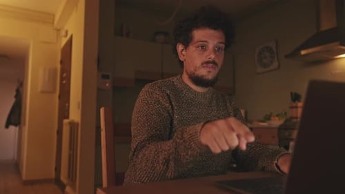 Man Talking and Using Laptop at Night