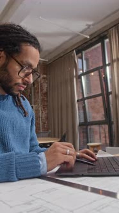 Architect Using Laptop while Developing Building Plan at Workplace