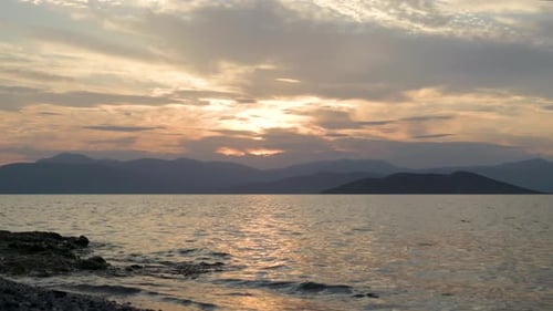 Stunning slow motion scenery at beach at sunset with mountain silhouettes