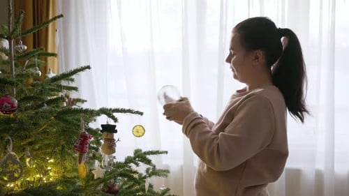 A Girl is Turning the Key of the Christmas Globe to Activate it - Medium Close Up