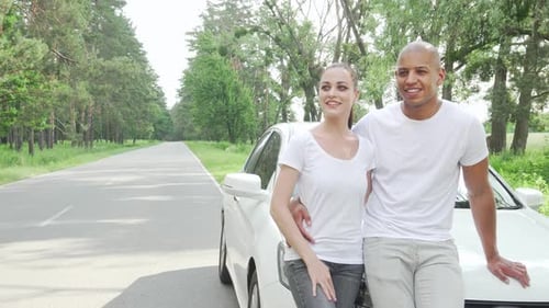 Smiling Couple Next to White Car on Country Road