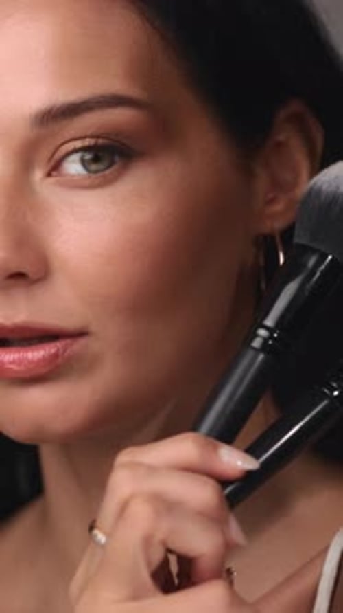 Woman Holding Makeup Brushes in Close Up Shot