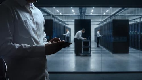 Server Room Staff Inspecting Data Center Using Tablet