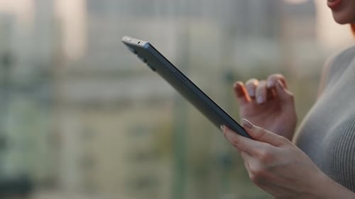 Closeup View of Woman Hand Touches Digital Tablet Screen on Sunset City Street
