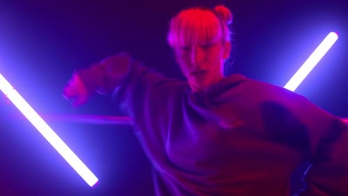 Stylish Girl Making Modern Hip Hop Moves in Neon Lights Indoors. Artistic