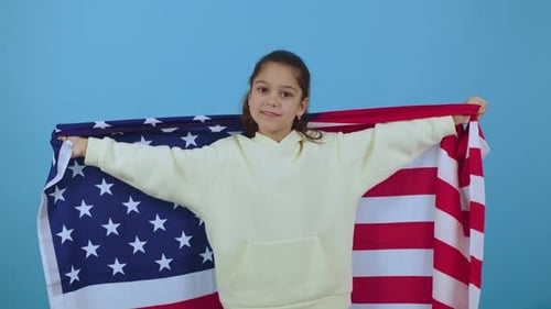 Smiling Child Holding American Flag Indoors