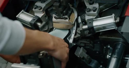 Macro of a shoemaker using a professional machine to bend the shoes and fix them according to the