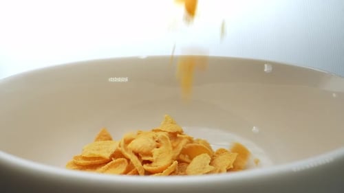 Corn Flakes Pouring Into a White Bowl