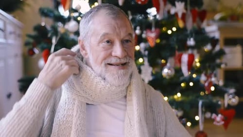 Senior man puts on scarf and winter hat