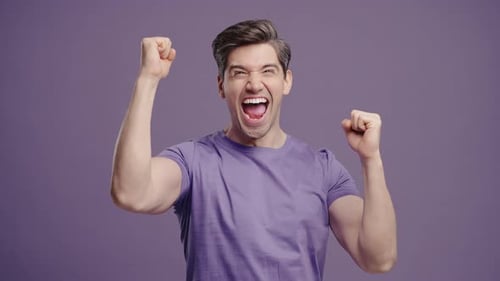 Excited Young Man Cheers With Fists Raised