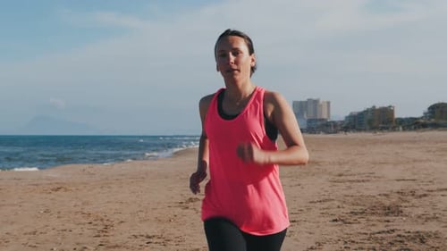 Woman Runs on the Beach on a Sunny Day