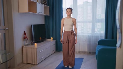 Woman Practicing Yoga in Living Room on Yoga Mat