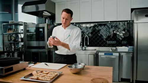 Adult Chef Blow Torching Food in Commercial Kitchen