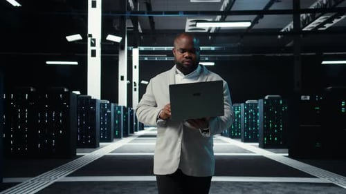 Data Center System Administrator Coding on Laptop Doing Software Updates