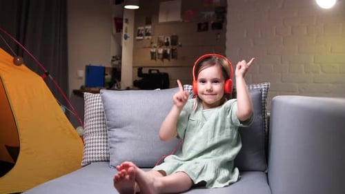 Little Girl Happily Listening to Music With Headphones