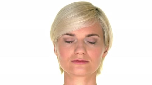 Woman with a calm facial expression closing her eyes on a white studio background. Copy space around