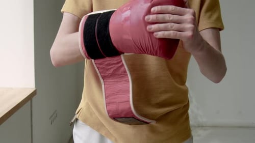 Person Putting On a Red Boxing Glove