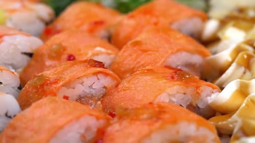 Sushi rolls are rotated in package after delivery. Shrimp roll in sushi set close up. Traditional