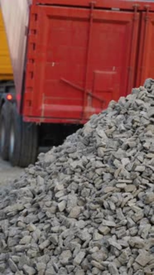 Heavy Dump Truck Unloading Gravel at Construction Site