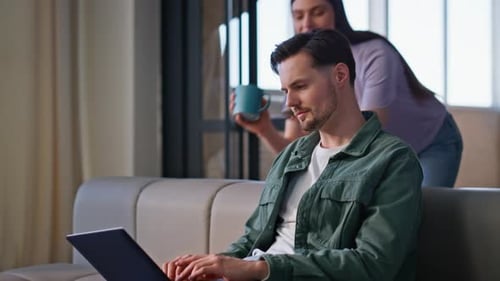 Couple Smiling at Laptop in Modern Apartment