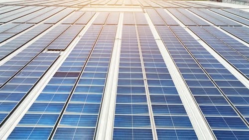 An aerial view reveals a solar panels blanketing the building's roof.