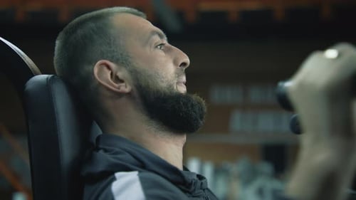 Athlete Performs Strength Exercises for Arms on Machine in Gym