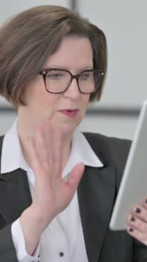 Woman Using Tablet Device for Video Call in Office