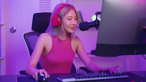 Woman in Pink Headphones Speaking into Microphone