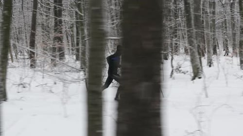Sportsman in Activewear Running at Winter Forest