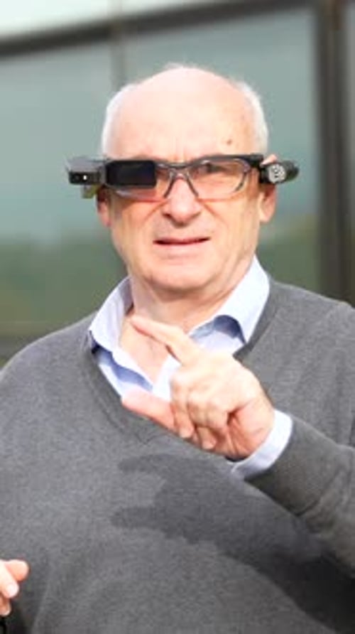 Man Demonstrating Futuristic Smart Glasses in Urban Setting