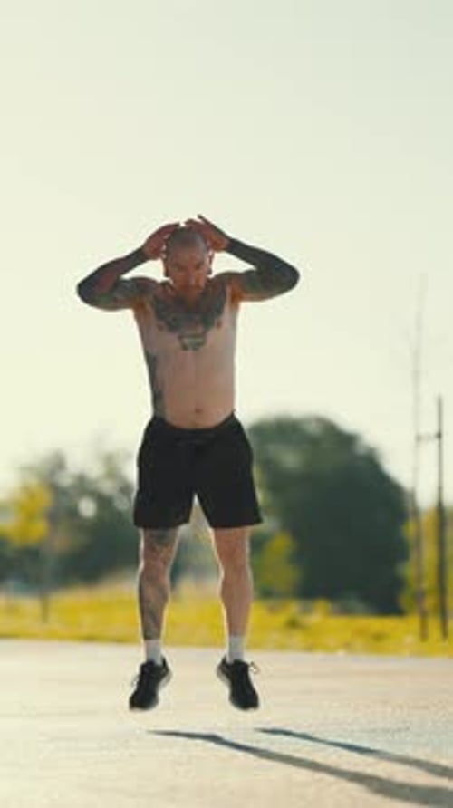 Homme tatoué faisant de l'exercice Burpee à l'extérieur