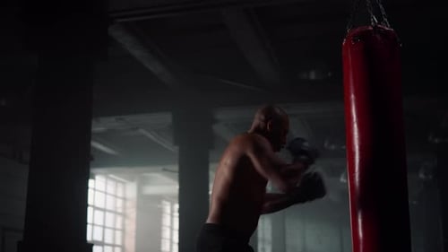 Male Boxer Punching Sports Bag in Sport Club. Angry Man Kicking Punch