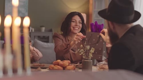 Family Celebrates Special Occasion with Gifts and Candles