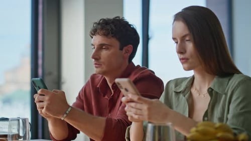 Gadgets dépendants de la famille focalisés assis au petit déjeuner à l'aide d'un smartphone en gros plan