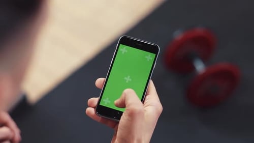 Hand Man Use Phone with Vertical Green Screen in Sport Club Gym Dumbbell Headphone Touch Approve